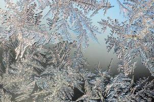 Snowflakes frost rime macro on window glass pane photo