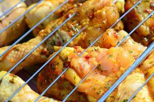 Marinated chicken legs on hot BBQ charcoal field grill photo