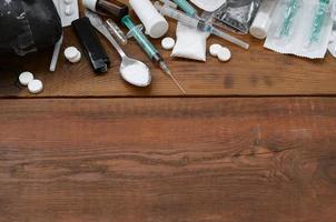 A lot of narcotic substances and devices for the preparation of drugs lie on an old wooden table photo