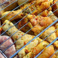 Marinated chicken legs on hot BBQ charcoal field grill photo