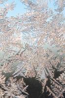 Snowflakes frost rime macro on window glass pane photo