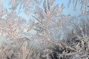 Snowflakes frost rime macro on window glass pane photo