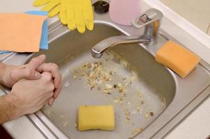 The housekeeper was faced with the problem of washing an overly dirty sink filled with food particles photo