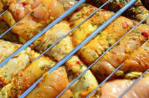 Marinated chicken legs on hot BBQ charcoal field grill photo