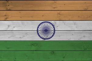 bandera india representada en colores de pintura brillante en una pared de madera vieja. banner texturizado sobre fondo áspero foto