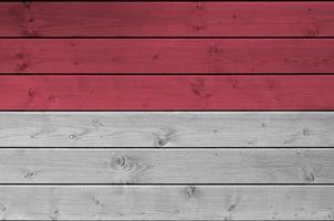 Monaco flag depicted in bright paint colors on old wooden wall. Textured banner on rough background photo