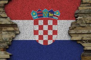 Croatia flag depicted in paint colors on old stone wall closeup. Textured banner on rock wall background photo