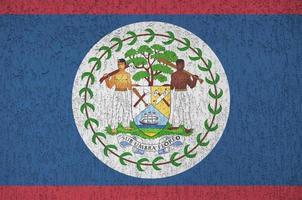 Belize flag depicted in bright paint colors on old relief plastering wall. Textured banner on rough background photo