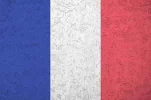 France flag depicted in bright paint colors on old relief plastering wall. Textured banner on rough background photo