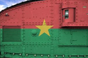 bandera de burkina faso representada en la parte lateral del primer plano del tanque blindado militar. antecedentes conceptuales de las fuerzas armadas foto