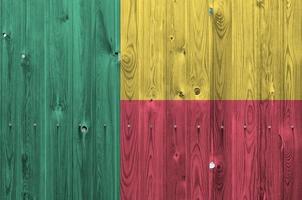 Benin flag depicted in bright paint colors on old wooden wall. Textured banner on rough background photo