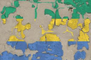 Gabon flag depicted in paint colors on old obsolete messy concrete wall closeup. Textured banner on rough background photo