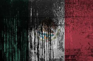 Mexico flag depicted in paint colors on old and dirty oil barrel wall closeup. Textured banner on rough background photo