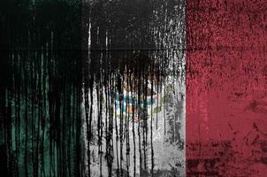 Mexico flag depicted in paint colors on old and dirty oil barrel wall closeup. Textured banner on rough background photo