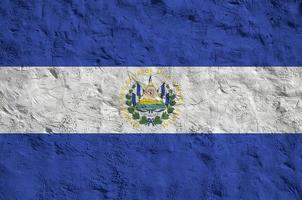 El Salvador flag depicted in bright paint colors on old relief plastering wall. Textured banner on rough background photo