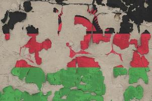 Malawi flag depicted in paint colors on old obsolete messy concrete wall closeup. Textured banner on rough background photo