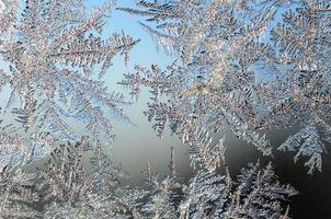 Snowflakes frost rime macro on window glass pane photo