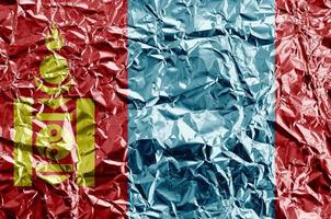 Mongolia flag depicted in paint colors on shiny crumpled aluminium foil closeup. Textured banner on rough background photo