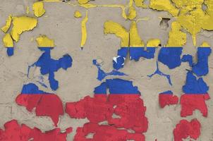 Venezuela flag depicted in paint colors on old obsolete messy concrete wall closeup. Textured banner on rough background photo