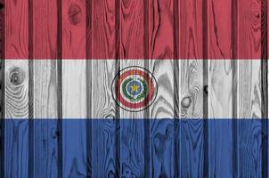 Paraguay flag depicted in bright paint colors on old wooden wall. Textured banner on rough background photo