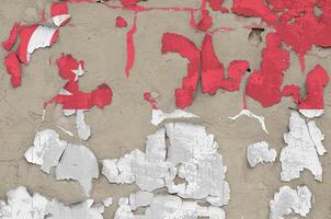 Singapore flag depicted in paint colors on old obsolete messy concrete wall closeup. Textured banner on rough background photo