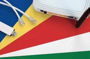 Seychelles flag depicted on table with internet rj45 cable, wireless usb wifi adapter and router. Internet connection concept photo