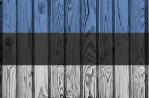 Estonia flag depicted in bright paint colors on old wooden wall. Textured banner on rough background photo