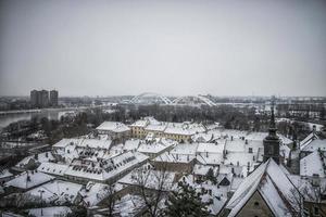 A panoramic view of Petrovaradin rooftops covered with snow photo