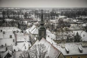 A panoramic view of Petrovaradin rooftops covered with snow photo