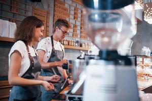 Working together. Two young cafe employees indoors. Conception of business and service photo