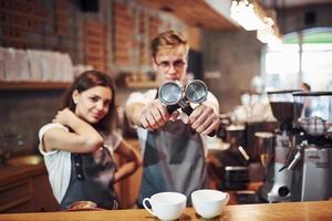 Front view. Two young cafe workers indoors. Conception of business and service photo