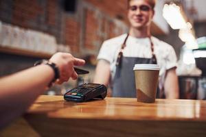 joven trabajador de café masculino en el interior. concepción de negocio y servicio foto