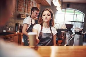 Servicio al Cliente. dos jóvenes trabajadores de cafeterías en el interior. concepción del negocio foto