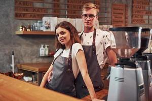 posando para la cámara. dos jóvenes trabajadores de cafeterías en el interior. concepción de negocio y servicio foto