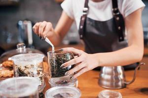 Making tea. Young female cafe worker indoors. Conception of business and service photo