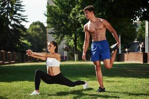 Together is funnier. Man and woman have fitness day in the city at daytime in the park photo