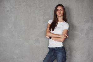 Warm in the room. Young beautiful woman in the studio standing against grey background photo