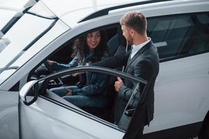 Simple and comfortable. Female customer and modern stylish bearded businessman in the automobile saloon photo