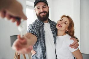 It's your home now. Happy couple together in their new house. Conception of moving photo