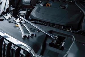 Top view. Repair tools lying down on the engine of automobile under the hood photo