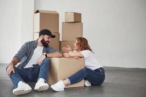 Girl tells something interesting. Happy couple together in their new house. Conception of moving photo