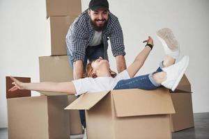 Like kids again. Happy couple together in their new house. Conception of moving photo