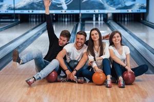 Positive emotions. Young cheerful friends have fun in bowling club at their weekends photo