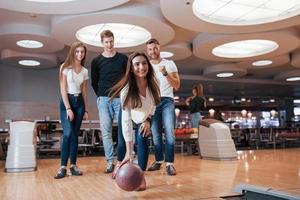 Happy team. Young cheerful friends have fun in bowling club at their weekends photo