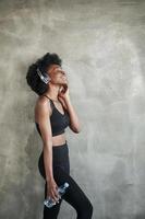 foto de estudio retrato de una chica afroamericana con ropa de fitness tomando un descanso después del entrenamiento