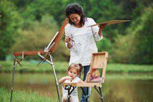 Keep practicing. Teaching granddaughter how to paint. In the natural parkland photo