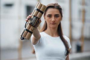 elementos digitales. mostrando bomba de tiempo. mujer joven sosteniendo un arma explosiva peligrosa en la mano