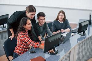 Look at this. Group of young people in casual clothes working in the modern office photo