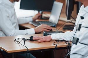 durante el día. hombre sospechoso pasa detector de mentiras en la oficina. haciendo preguntas. prueba de polígrafo foto