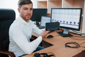 Digital device. Polygraph examiner works in the office with his lie detector's equipment photo